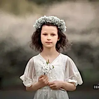 Jente i hvit kjole holder blomster