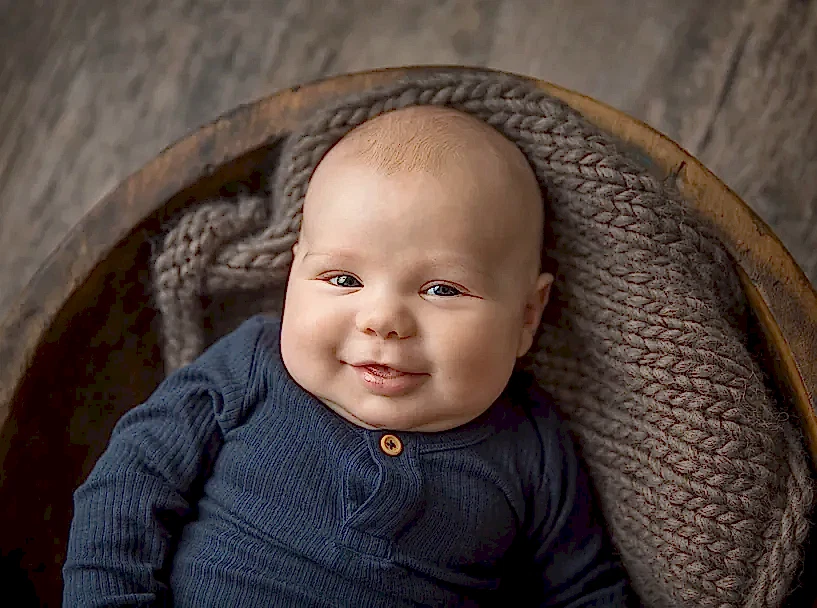 Smilende baby i en kurv