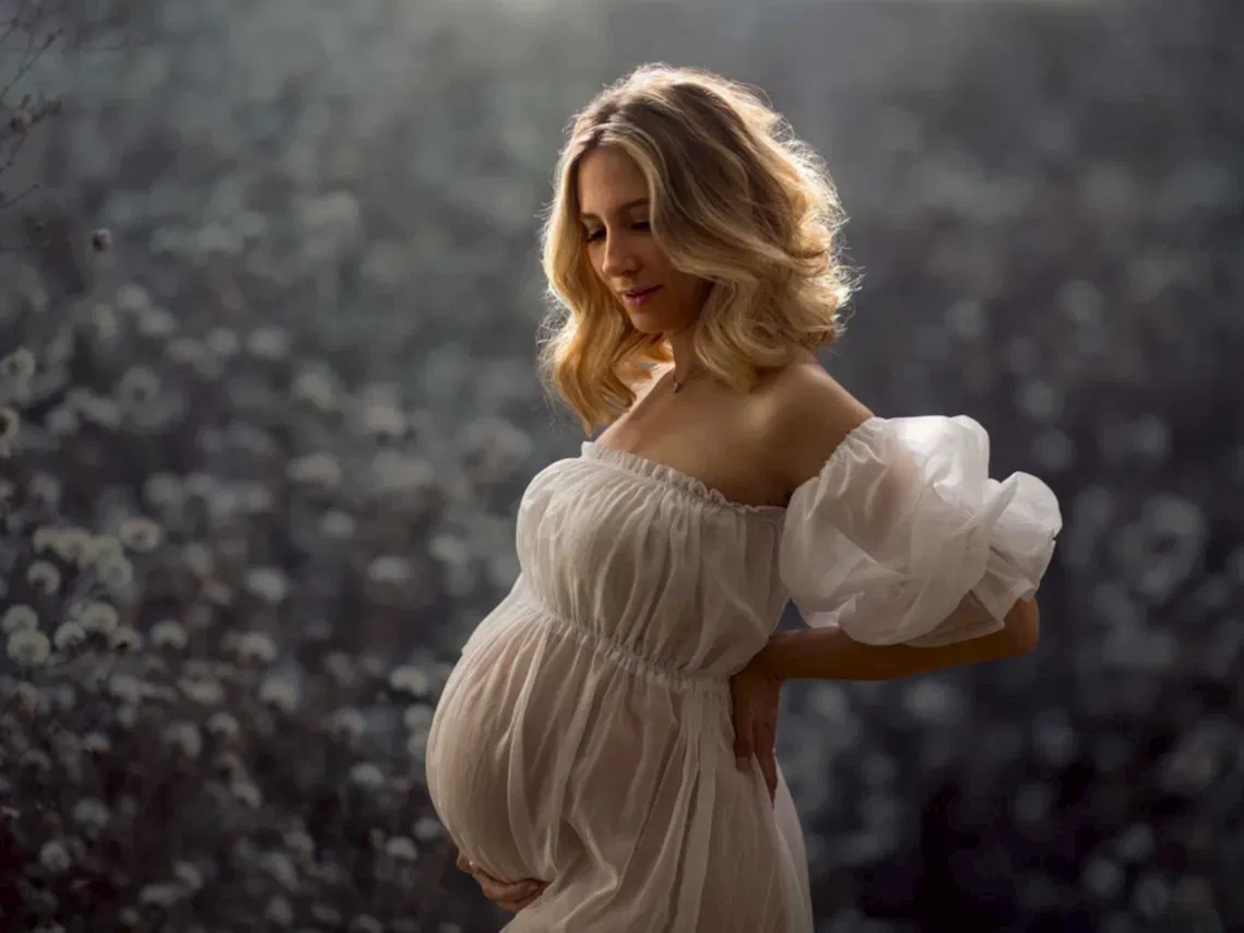 Gravid kvinne i hvit kjole