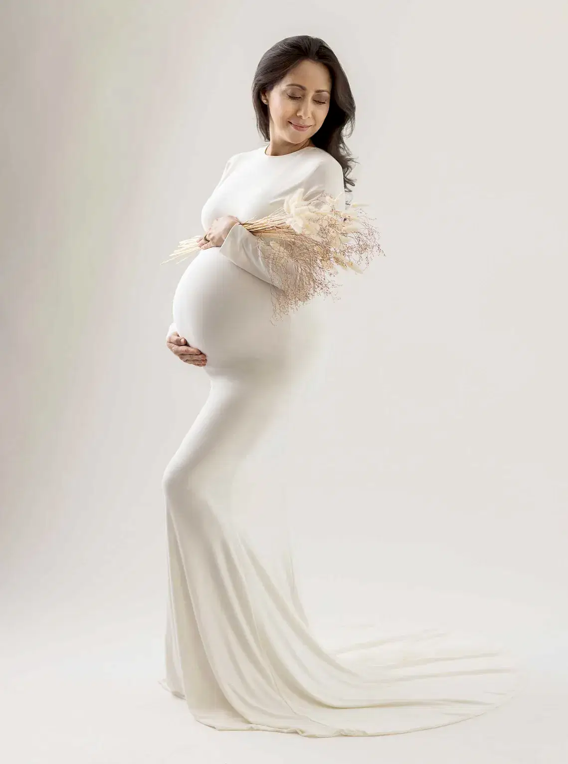 Gravid kvinne i tettsittende hvit kjole