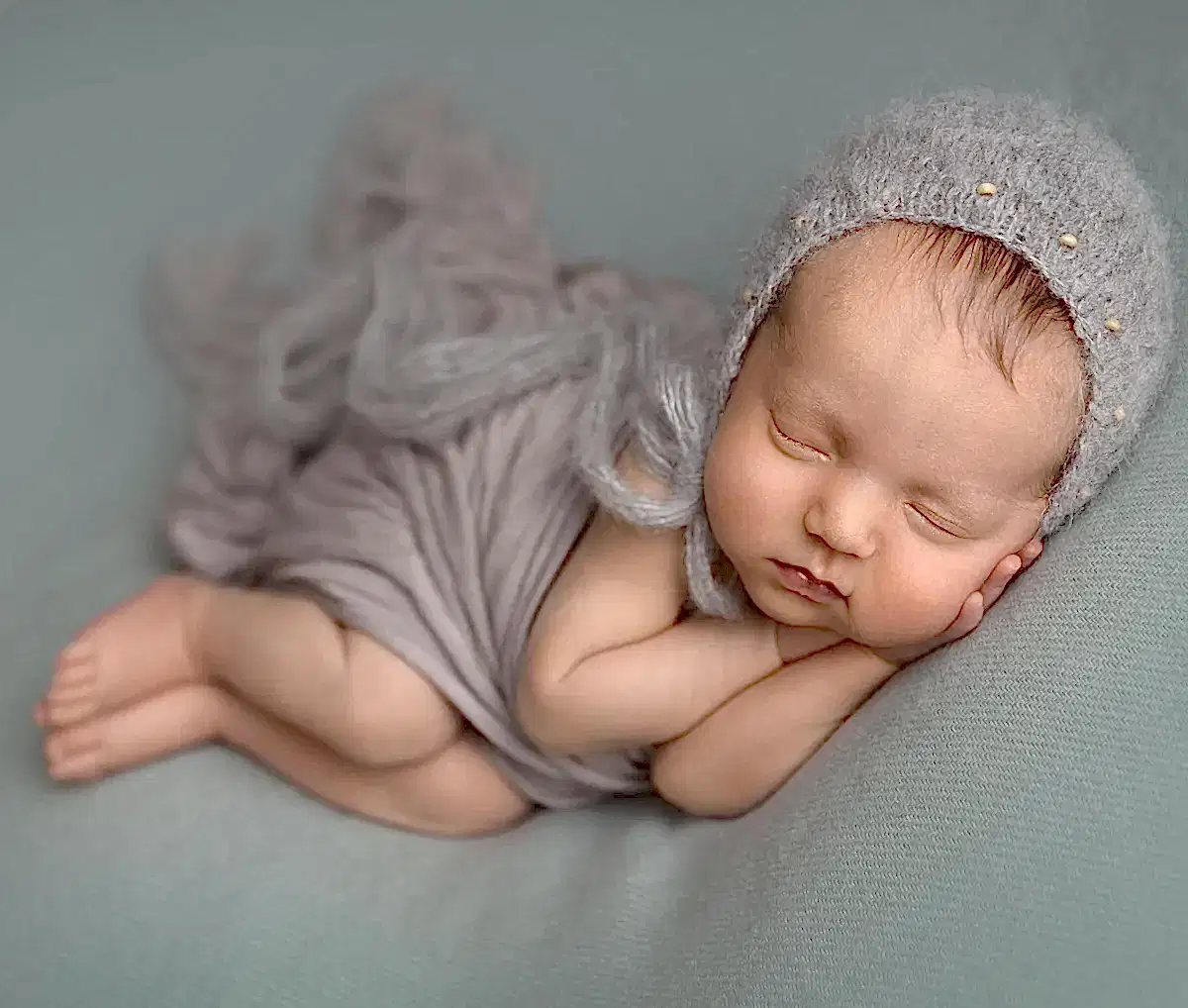 Baby sover på mintgrønt pledd