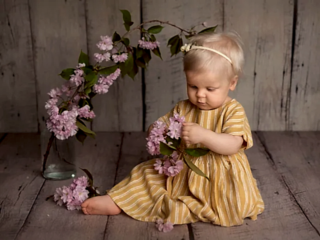 Jente i gul kjole holder blomster