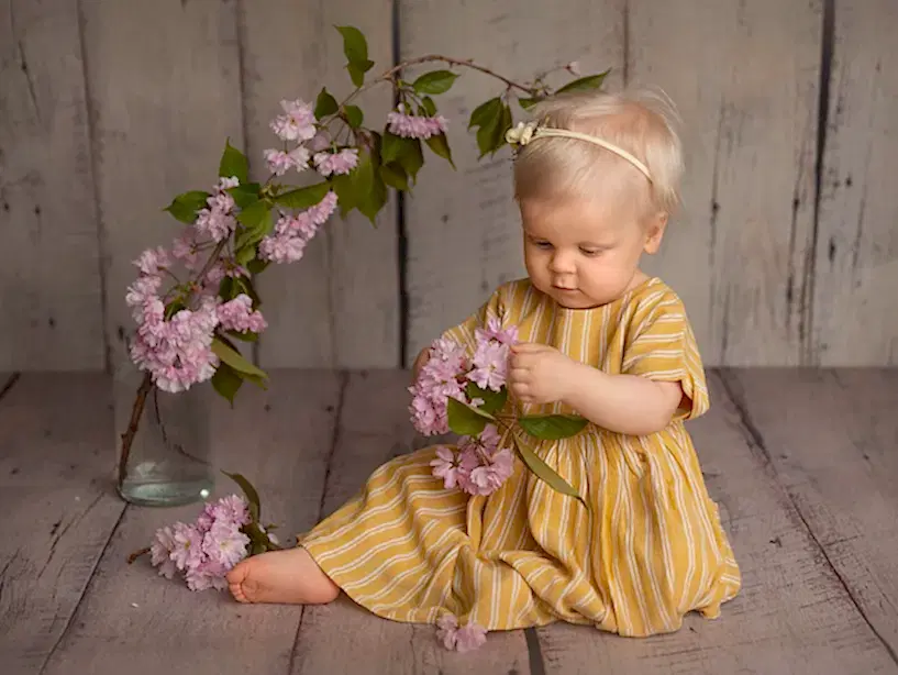 Jente i gul kjole holder blomster