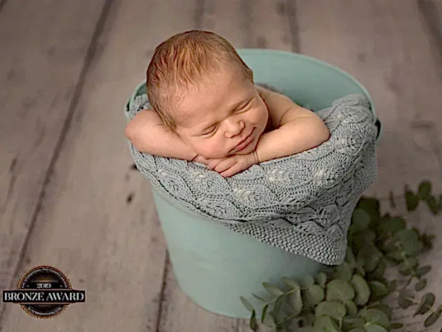 Baby ligger i grønn bøtte