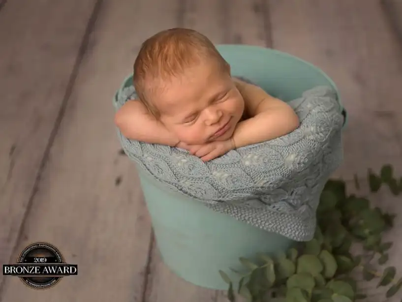 Baby ligger i grønn bøtte
